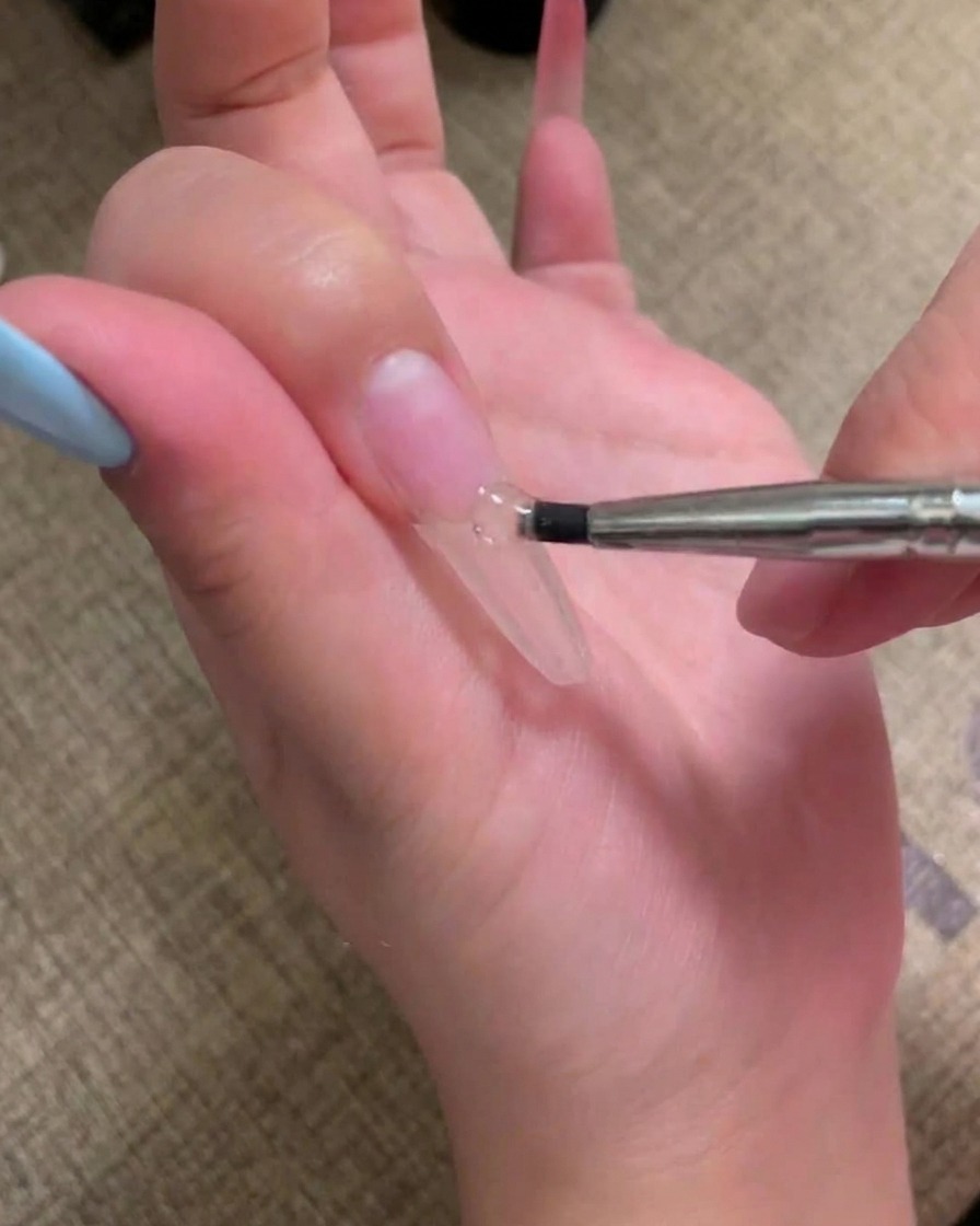 下準備をした爪に肌なじみの良いピンクのジェルポリッシュを塗るブラシ。