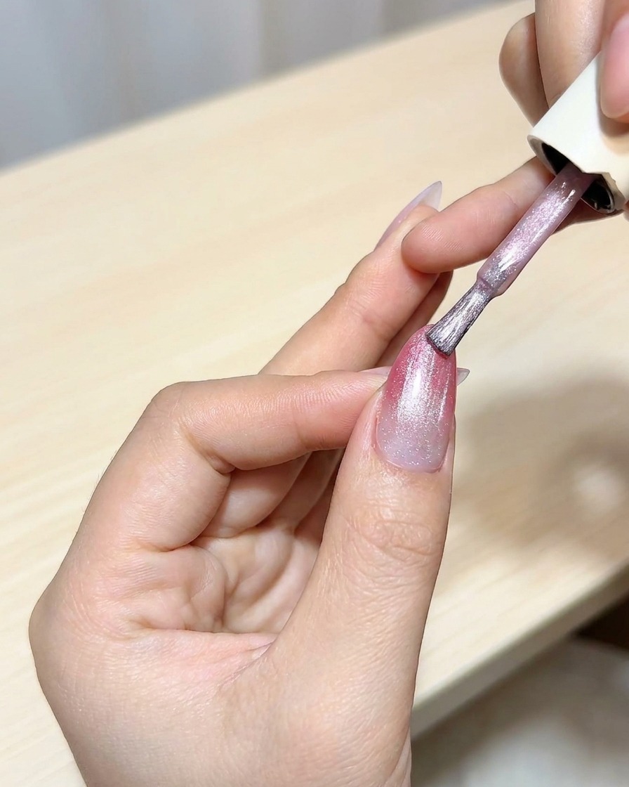 マゼンタのオンブレベースの上にキャットアイジェルを塗っている様子