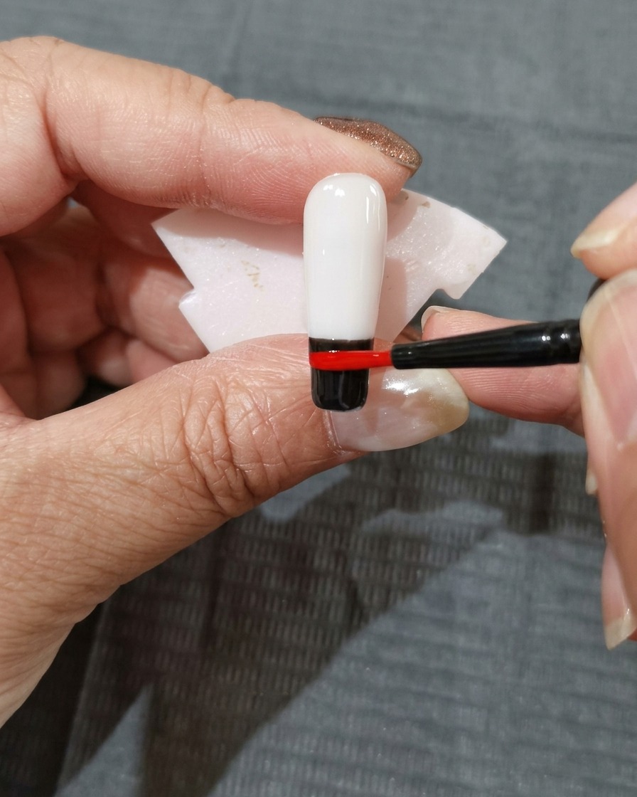 レッドのカラーバンドの上にオレンジレッドのジェルを塗布している様子。