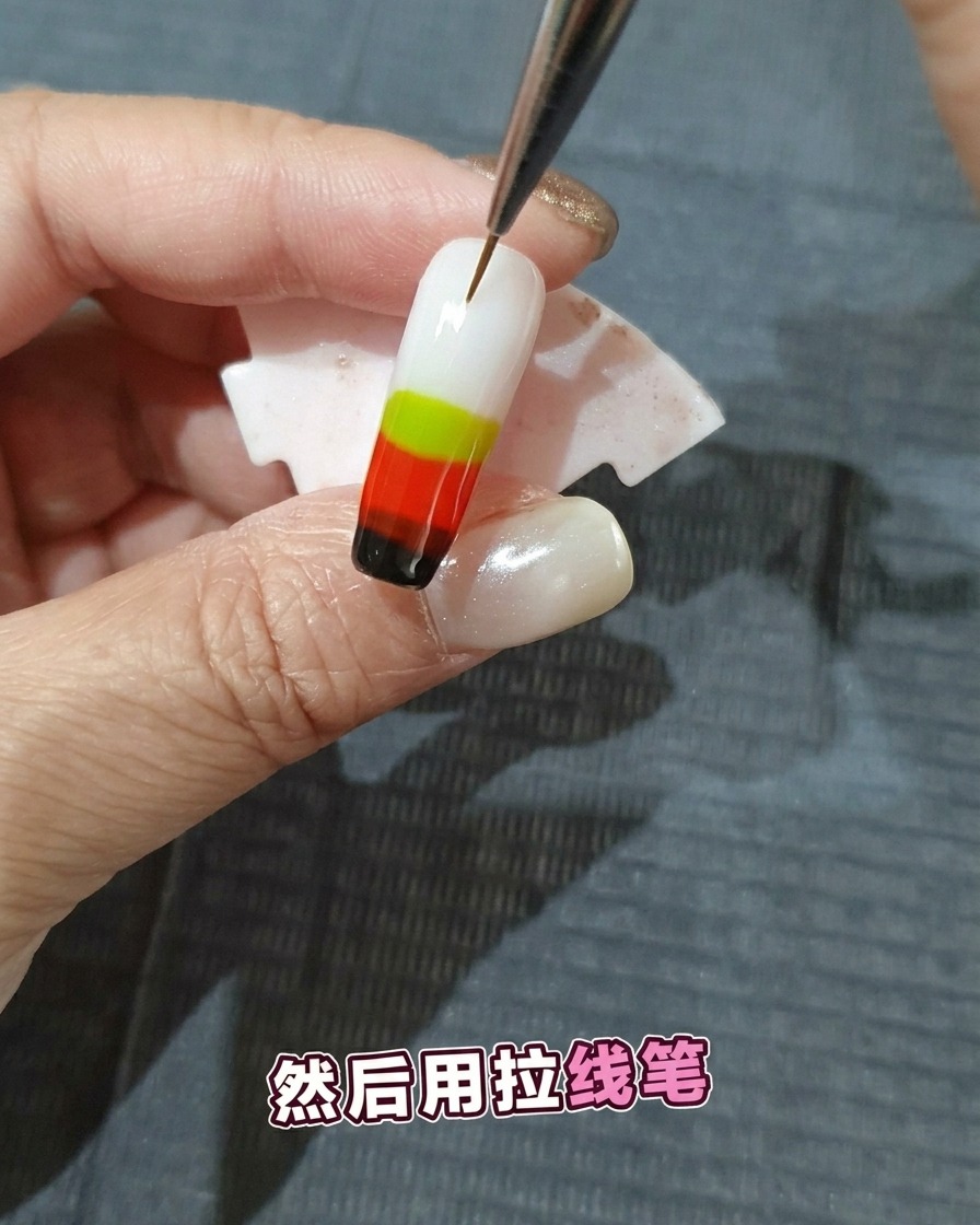 細いライナーブラシで濡れたジェルを引っ張り、炎の模様を作っている様子。