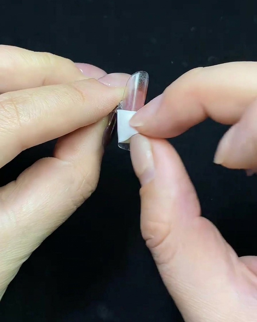 クリアチップにヌードカラーのジェルベースを塗布している様子。