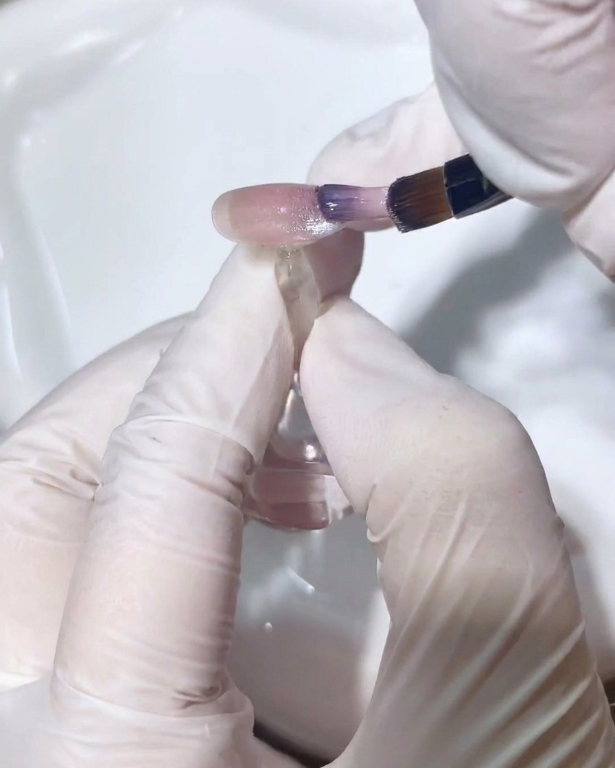 細筆を使ってキャッツアイジェルを優しくぼかし、グラデーションを作っている様子