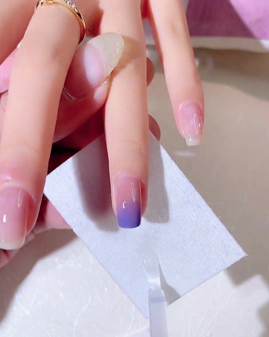 細いシルバーのジェルで、爪先にフレンチラインを描いている様子。