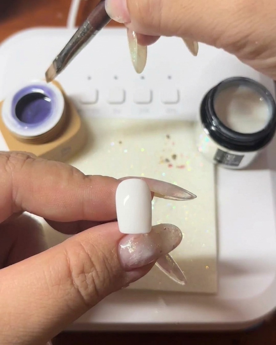 深みのあるパープルのキャッツアイジェルを爪に塗っている様子。
