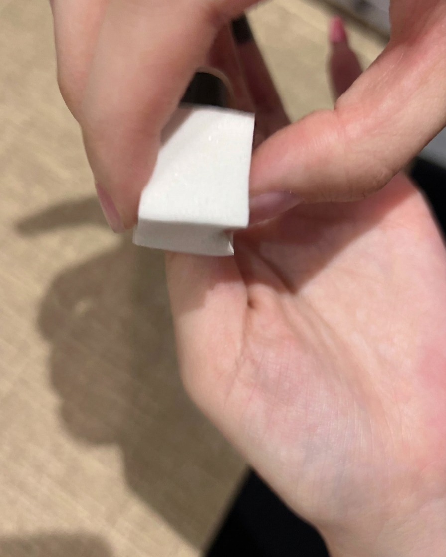 メイクスポンジを使ってピンクのジェルポリッシュを爪に軽く叩き込み、ふんわりとしたグラデーションを作っている様子。