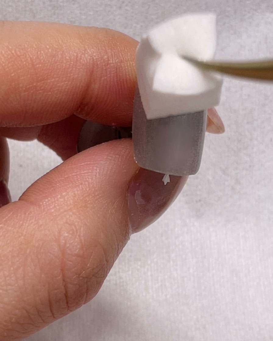爪の上でスポンジを使ってブルーのジェルを馴染ませ、オンブレ効果を作っているクローズアップ画像。