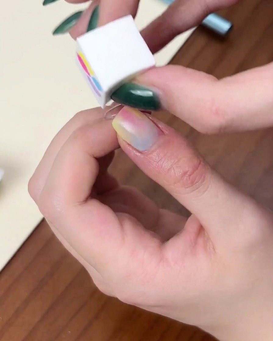 赤色のドーム型UV/LEDランプに指を入れ、硬化させている様子