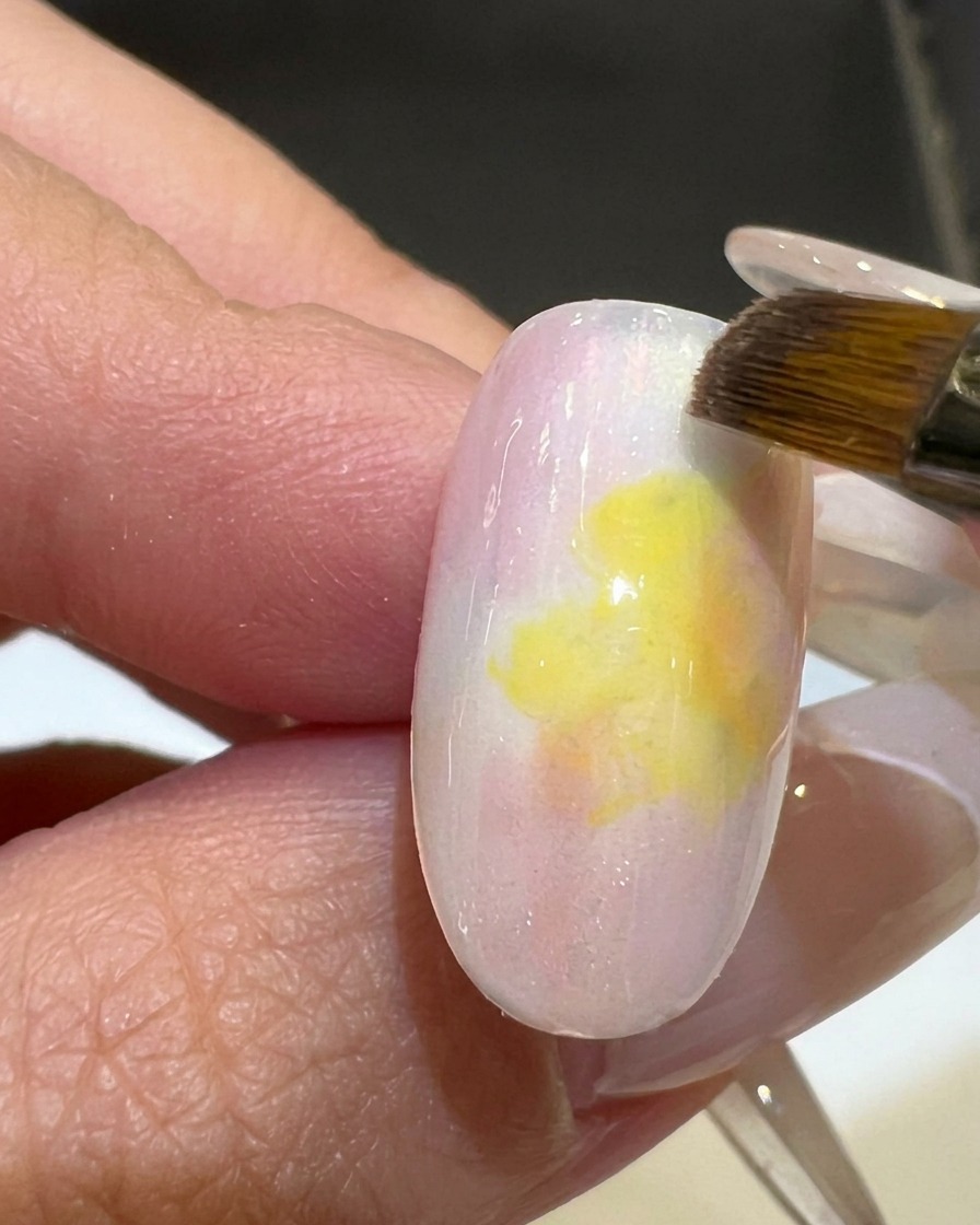 平筆を使ってピンクとイエローのグラデーションを滑らかに仕上げている様子。
