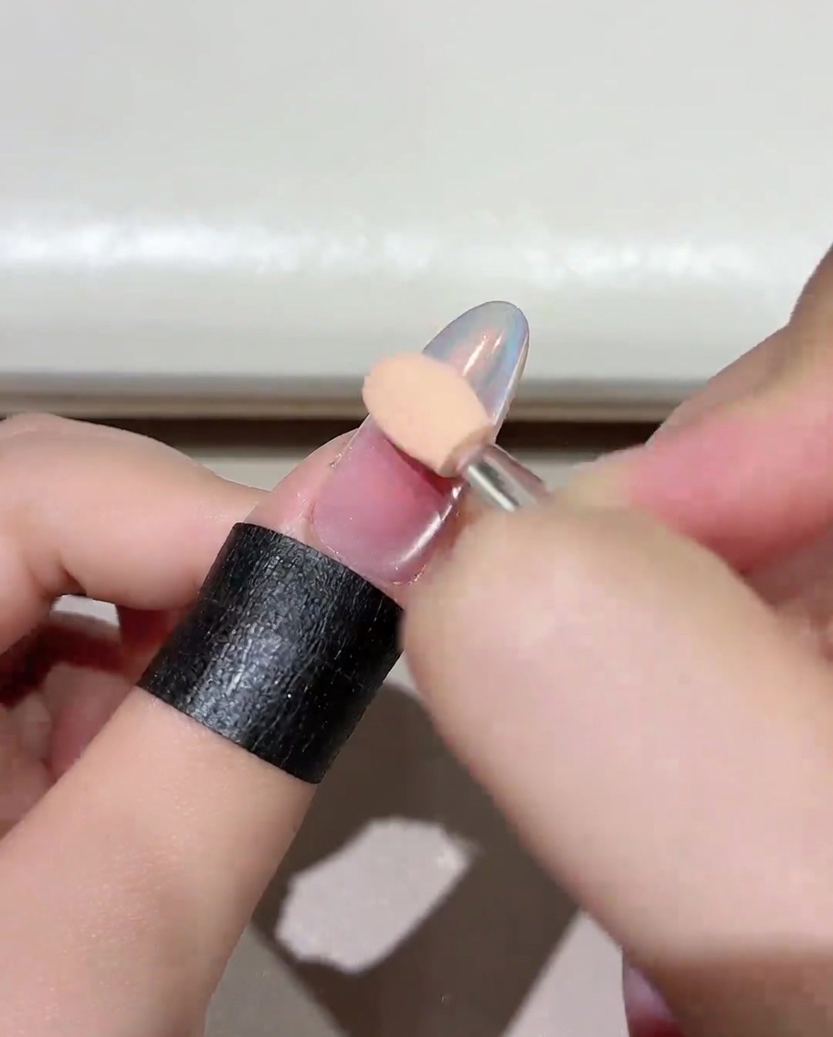 ブラッシュジェルを塗布した爪を、ネイル用UV/LEDランプに入れて硬化させている様子。