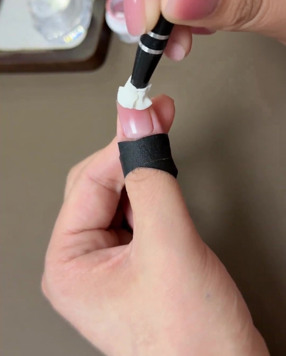 ピーチチーク効果を施した爪をLEDライトで硬化している様子。
