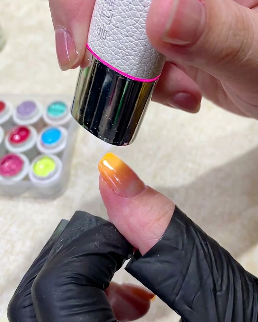 マニキュアした指がプロ仕様のUVネイルランプの中に入り、硬化されている様子。