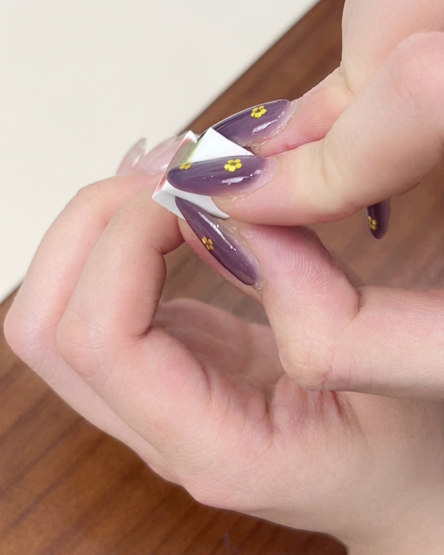メイク用スポンジを使い、爪のブルーのジェルを叩いてオンブレ効果を作っている様子。