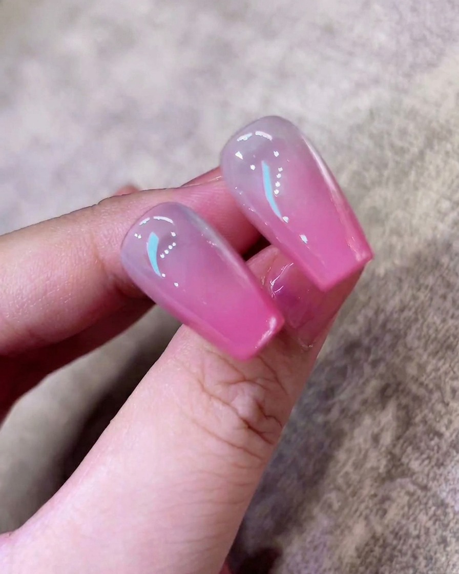 スポンジを使い、ネイルチップに柔らかなピンクのオンブレグラデーションを作っている様子。
