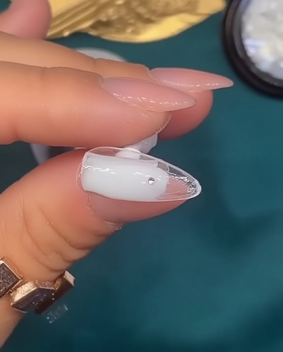 ナチュラルな爪に乳白色のジェルを塗っている様子