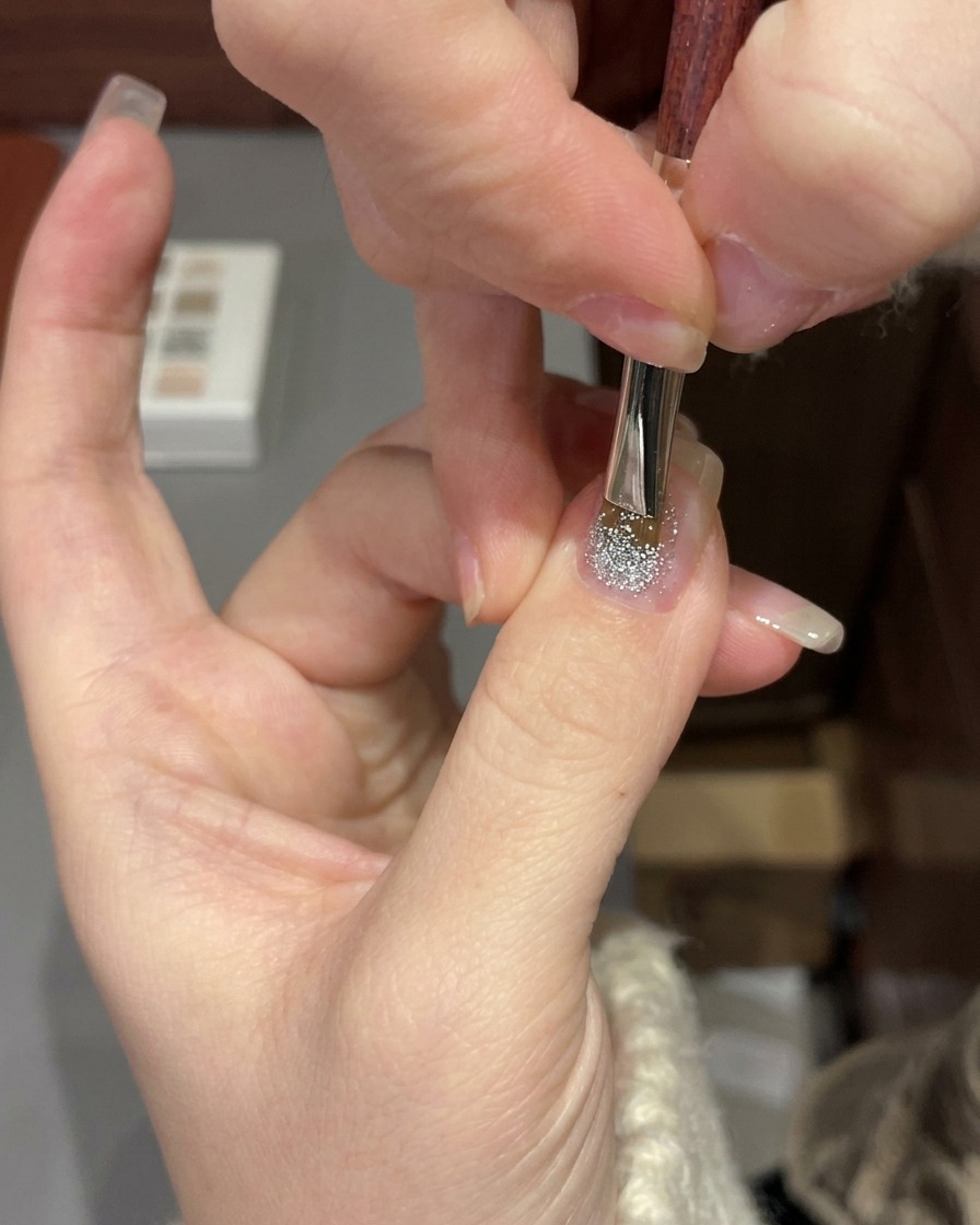 グリッタージェルを施した手をUV/LEDネイルランプに入れて硬化している様子。