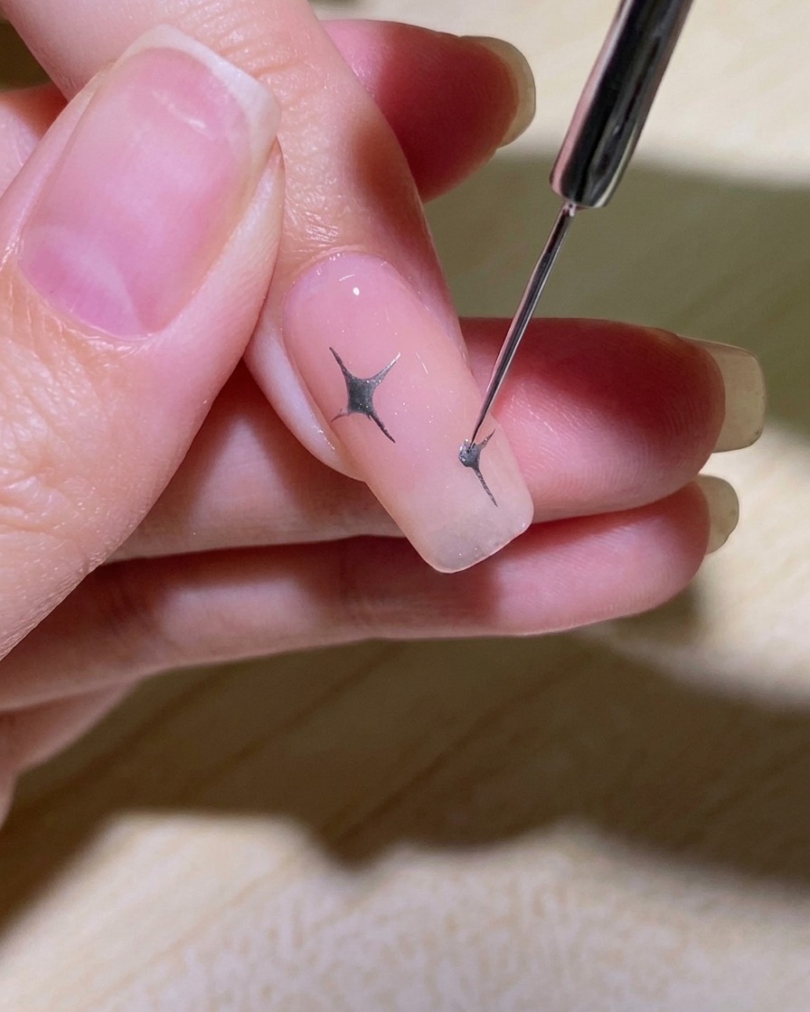 星の中心にドットを置き、さらに短い線を描き足してディテールを作る様子。