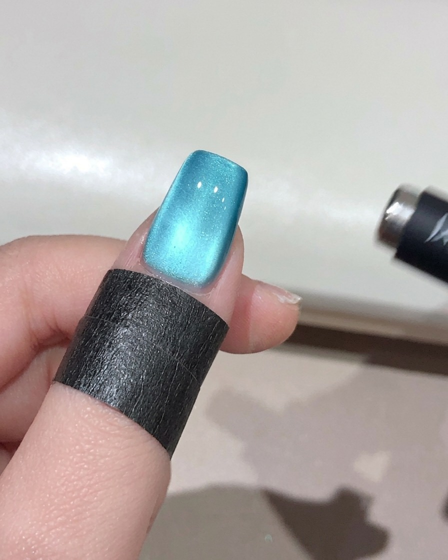 球体マグネットを爪の周りで動かし、立体的な輝きを作っている様子。