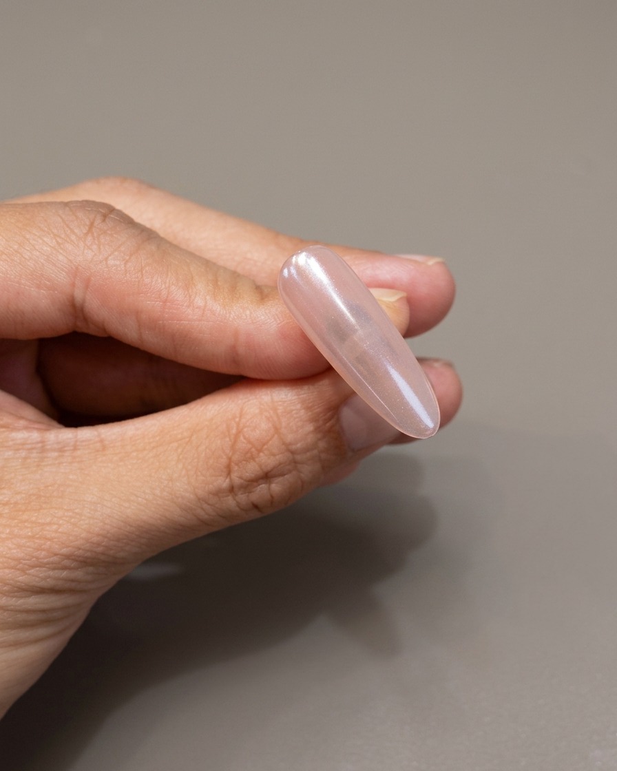 ミラー仕上げの爪の上に、透明な保護ジェルを塗布している様子。