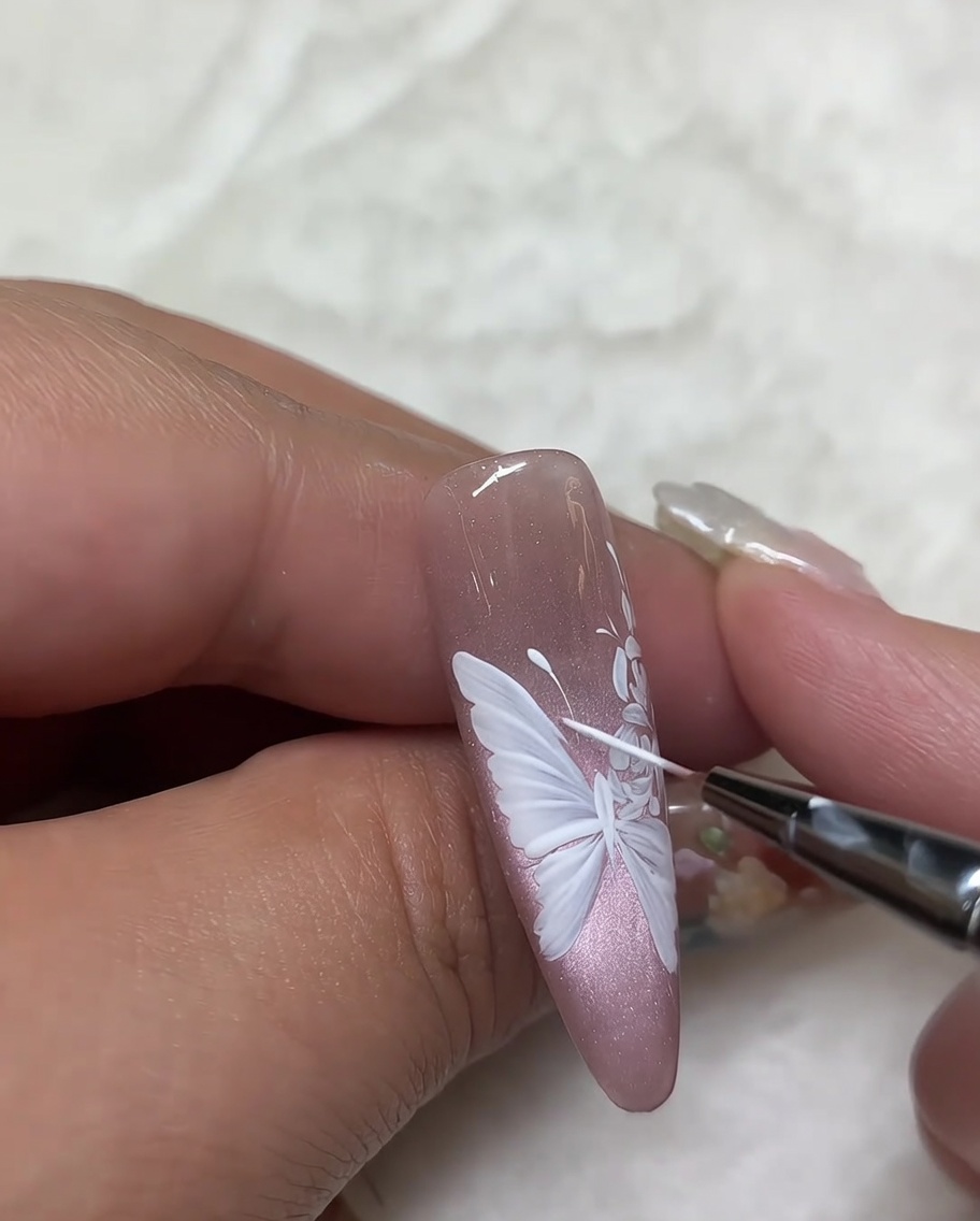 バラのペイントの細部を、細筆で最終チェックしている様子。