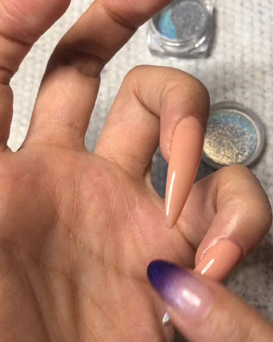 清潔な指を使って、爪先に乗せたパウダーの境界線を上にぼかし、自然なグラデーションを作っている様子。