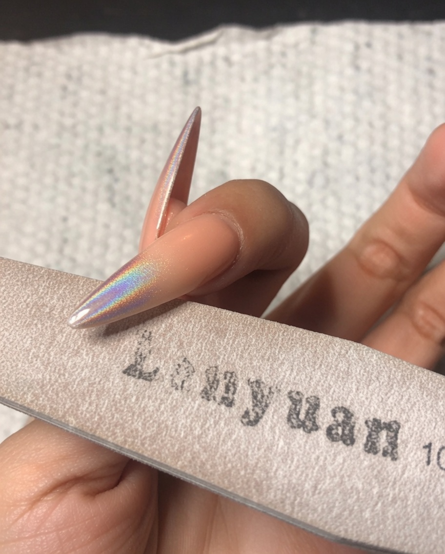 スポンジバッファーを使って、スティレットネイルの先端を軽く整えている様子。