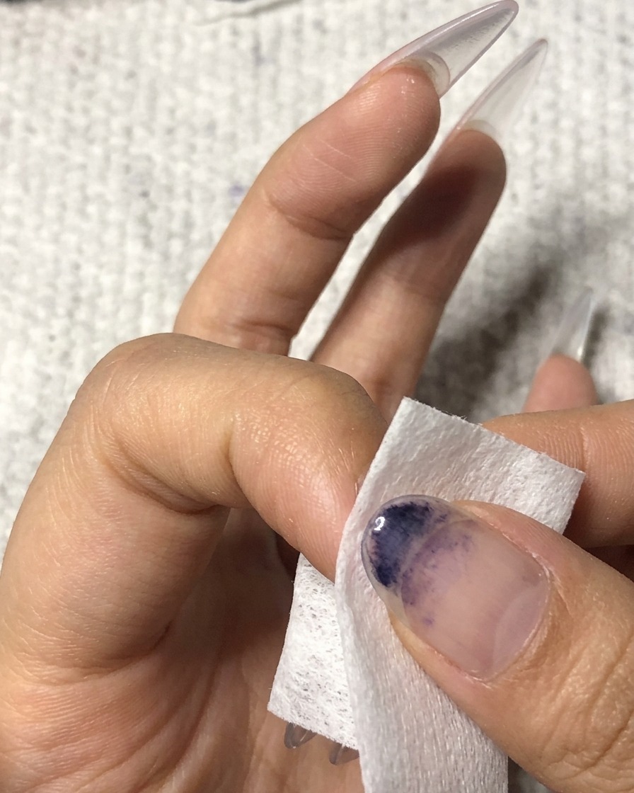 薬指の表面をワイプで丁寧に拭き取っている様子。