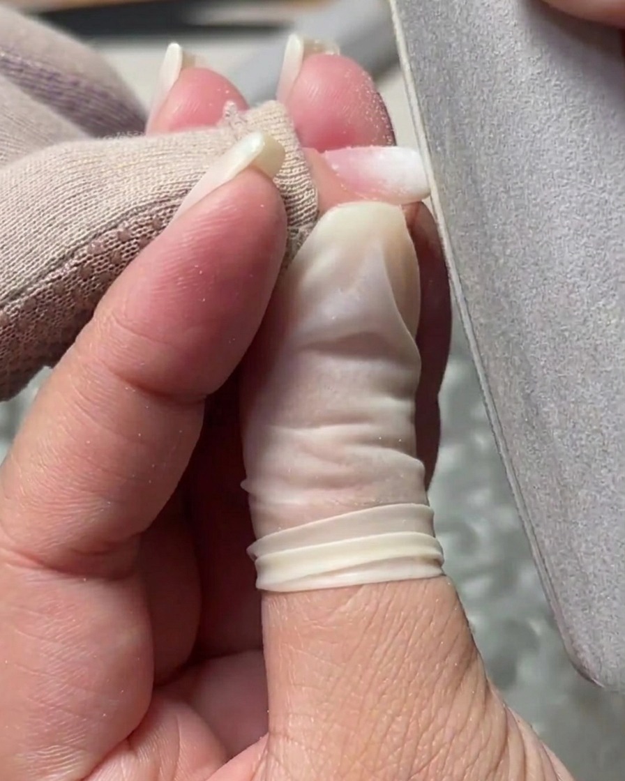 ネイルファイルを使用してジェルの表面を滑らかにし、エッジの形を整えている様子。