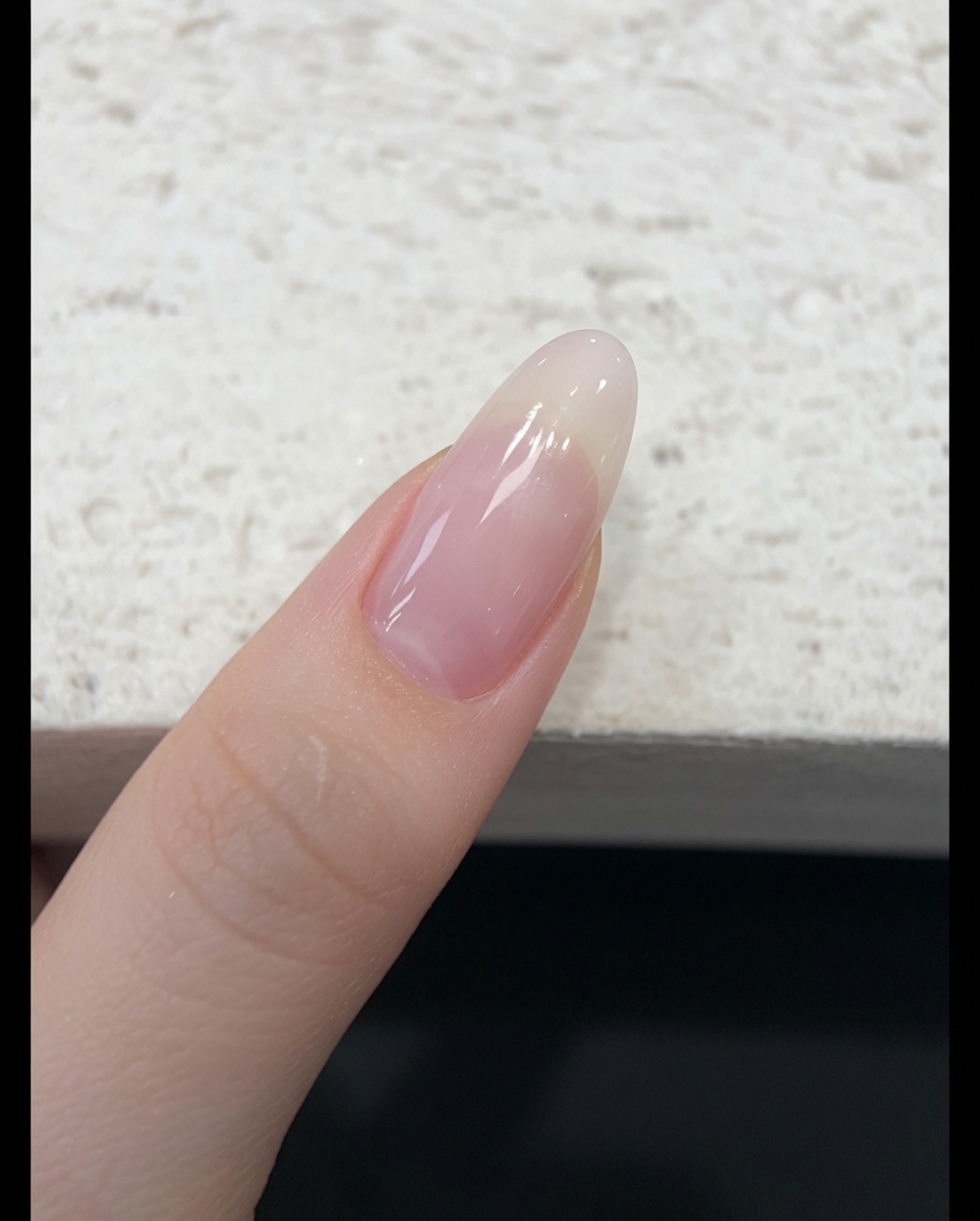 自爪にシアーなヌードピンクのジェリージェルをブラシで塗布している様子。