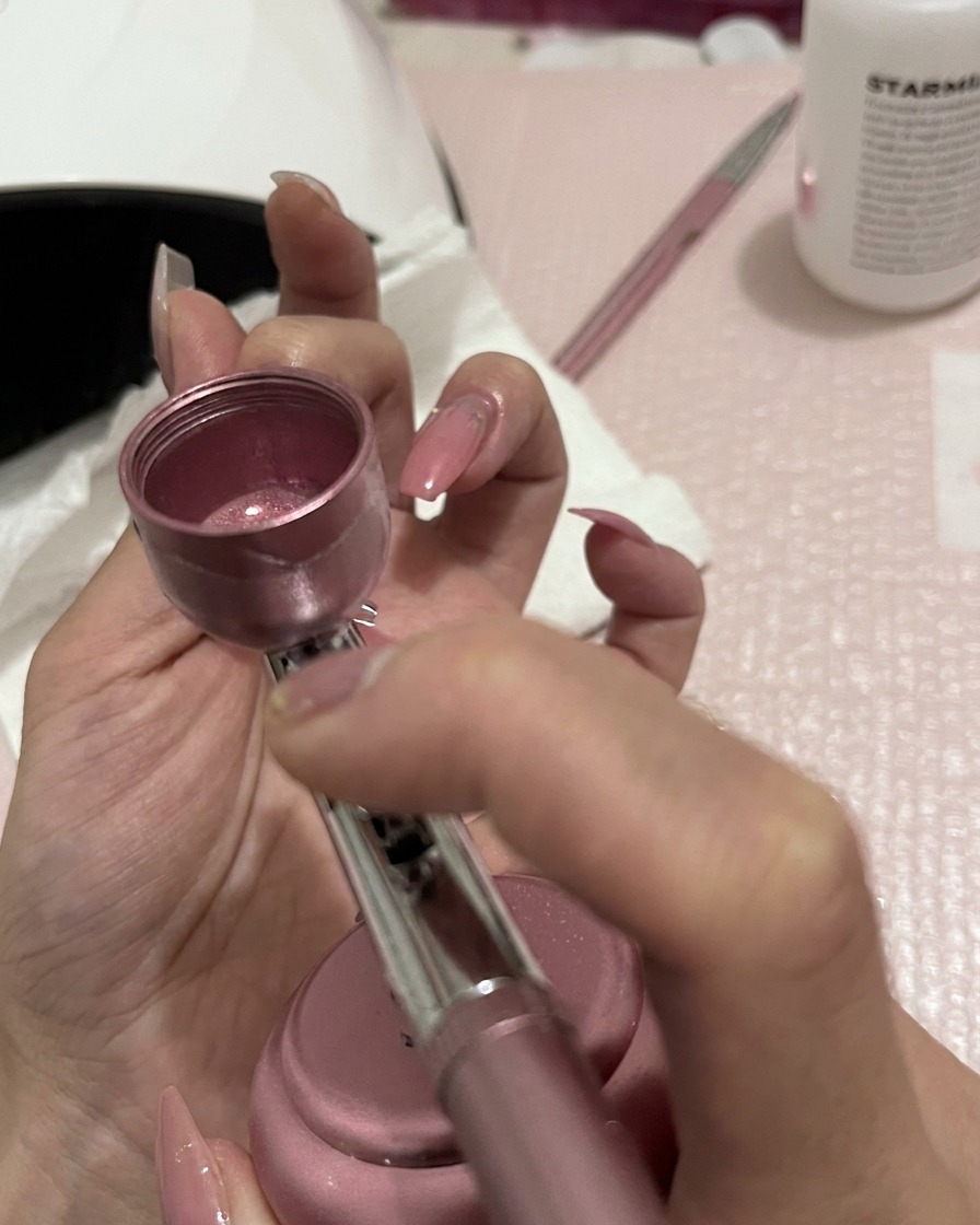 爪先に向かって軽く均一に吹き付け、グラデーションを仕上げている様子。