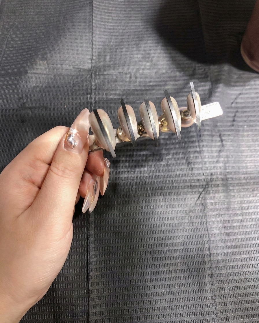 別のネイルチップセットにエアブラシで白のジェルを吹き付けている様子。