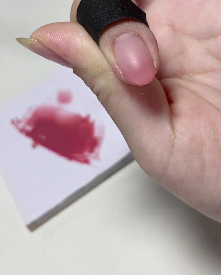 ネイル筆で爪先にたっぷりとピンクジェルを乗せている様子。