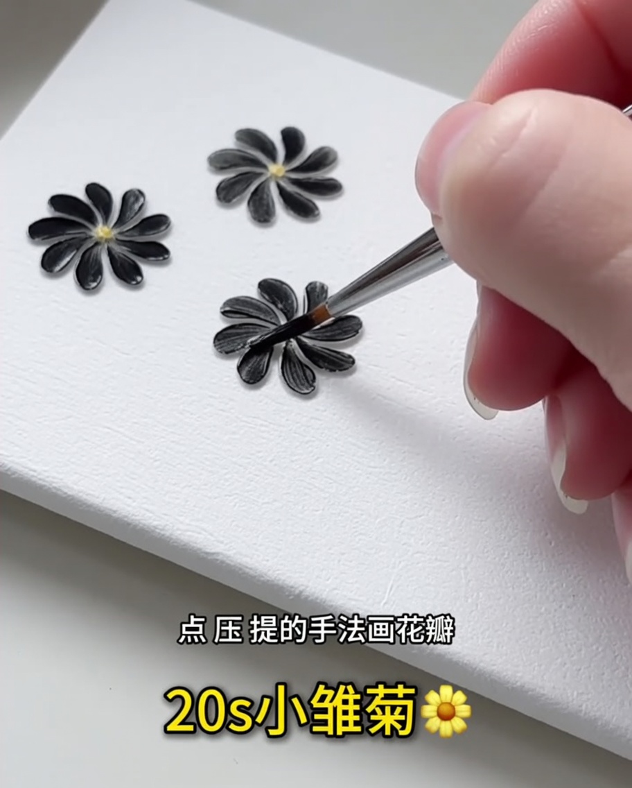 細いライナーブラシを使い、白いネイルチップに黒いジェルの花びらを1枚描いているクローズアップ画像。