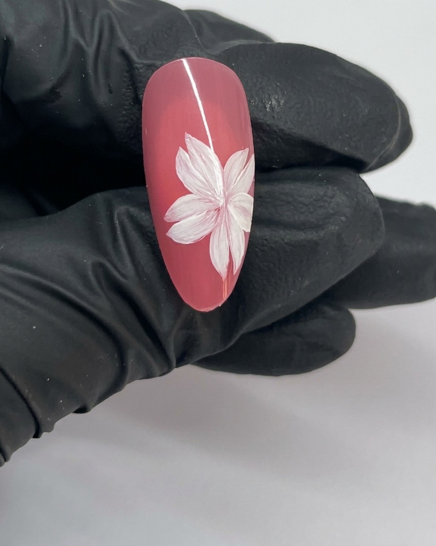 桜のネイルアートの完成図。花の中心に白い点(しべ)が描かれている様子。