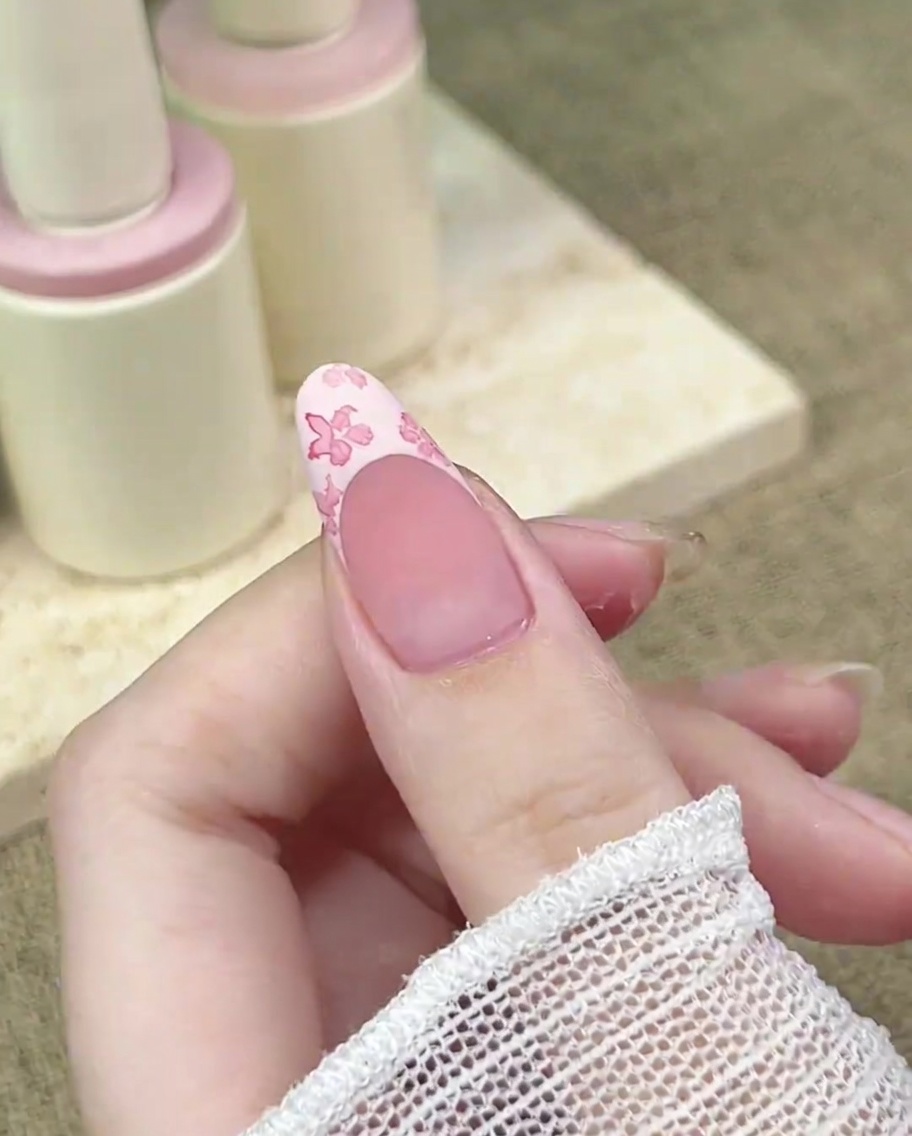細いブラシを使い、花の中心に濃いピンクをのせて奥行きを出している様子。