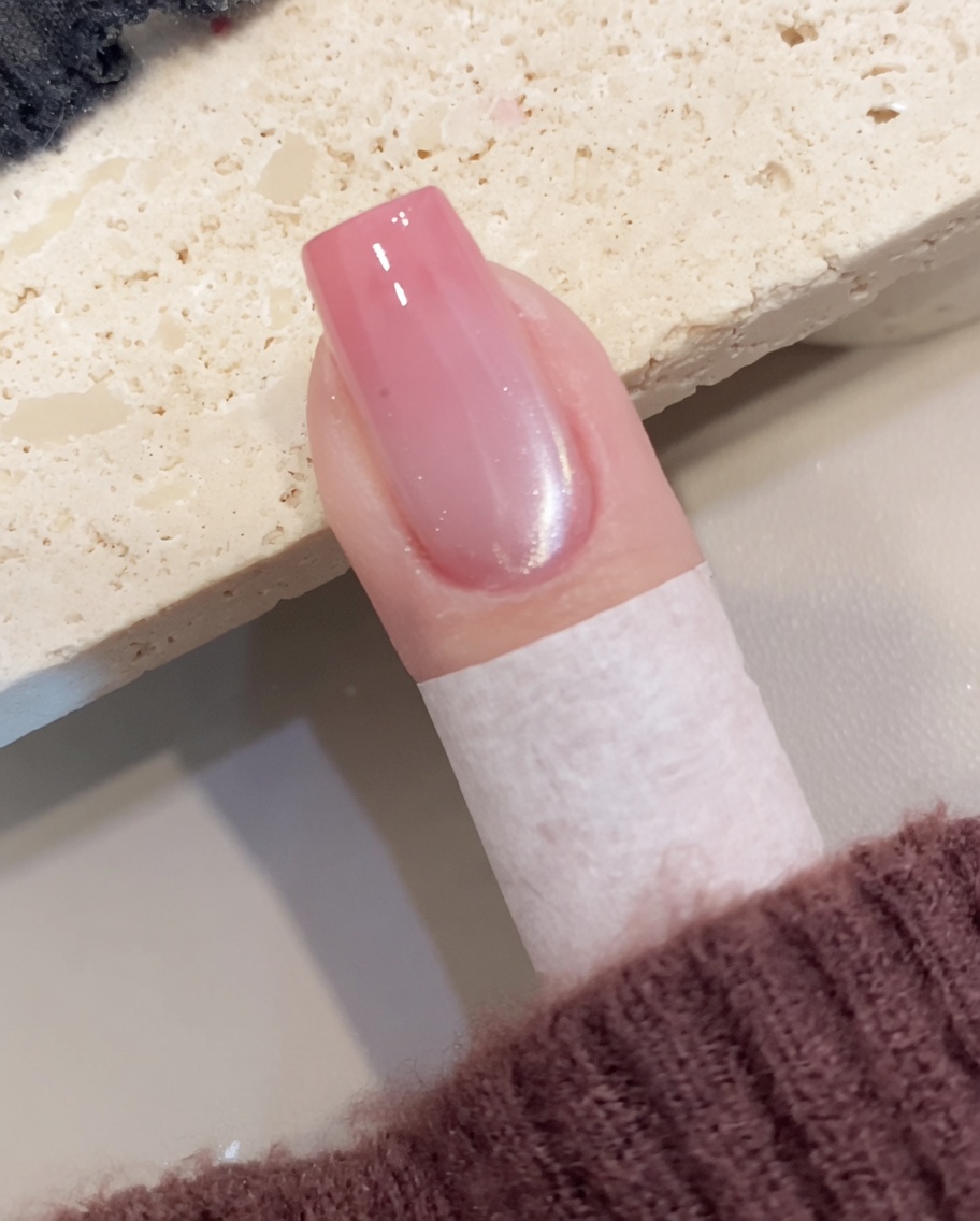 準備された爪に、シマーを含んだキャッツアイジェルを筆で薄く塗り広げている様子。