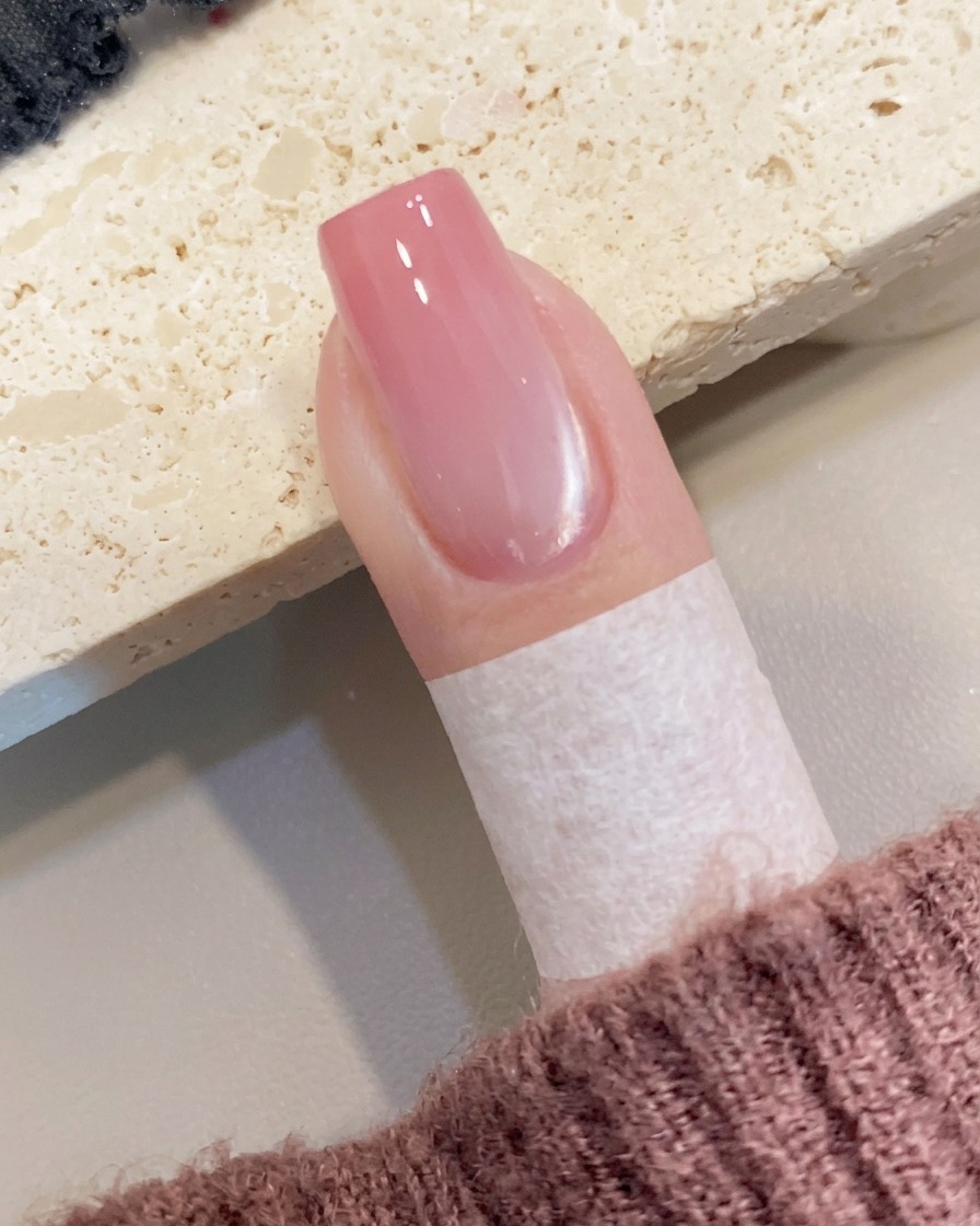 筆を使って爪の先端にピーチカラーのジェルを少量置いている様子。