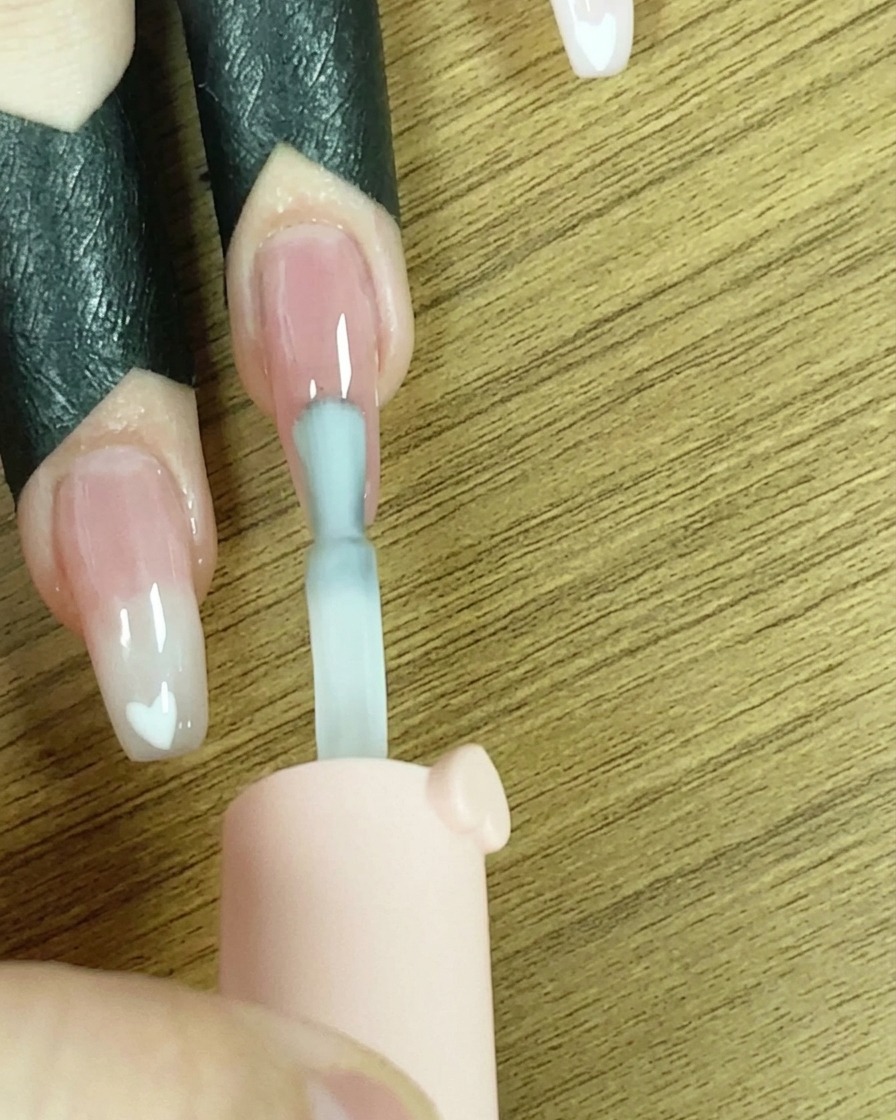 爪先にホワイトのジェルをライン状に塗っている様子。