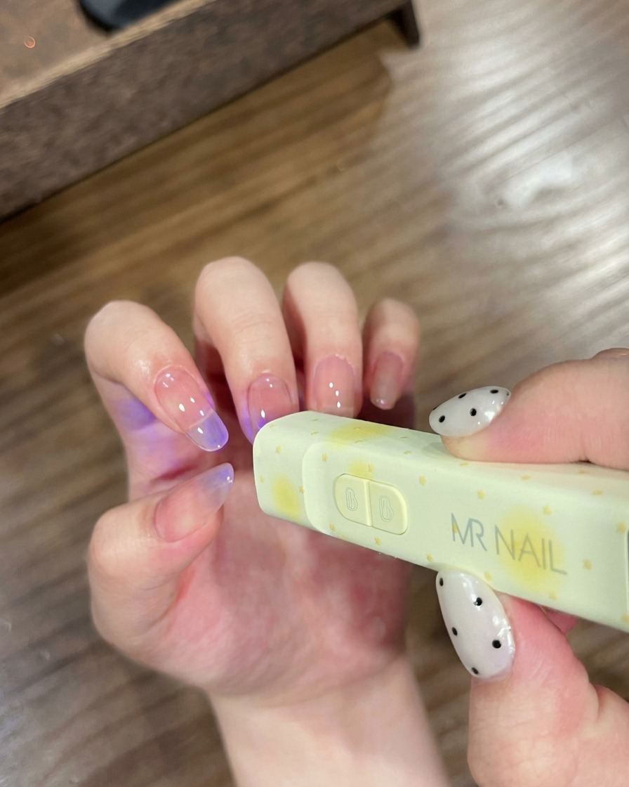 小型のMR NAIL UVライトの下で爪を硬化させている様子。
