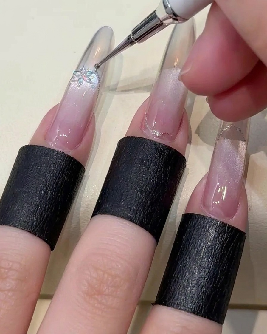ピンセットで雪の結晶パーツと小さなビーズをジェルに乗せている様子。
