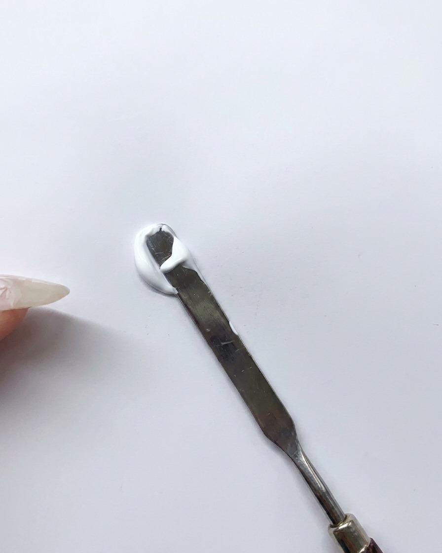 スパチュラでブルーとホワイトのジェルをパレット上で混ぜている様子。