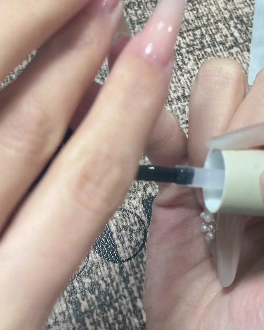 トップコートを塗った後、ジェルをセルフレベリングさせるために手を逆さにしている様子。