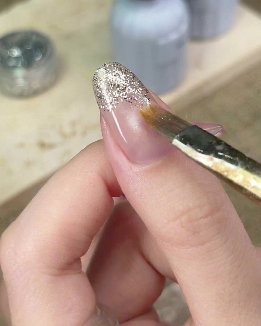 細筆を使ってシルバーラメの境界線を慎重にぼかし、自然なグラデーションを作っている様子。
