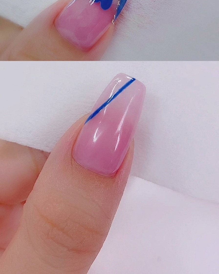 細いネイルアート用ライナーブラシで、ハートの輪郭内をブルーのジェルで塗りつぶしている様子。