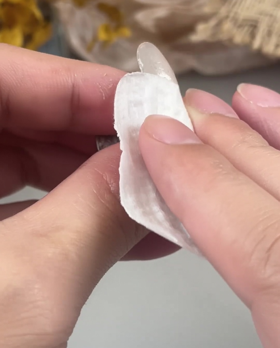 ワイプで硬化したジェル表面を拭き取っている様子。