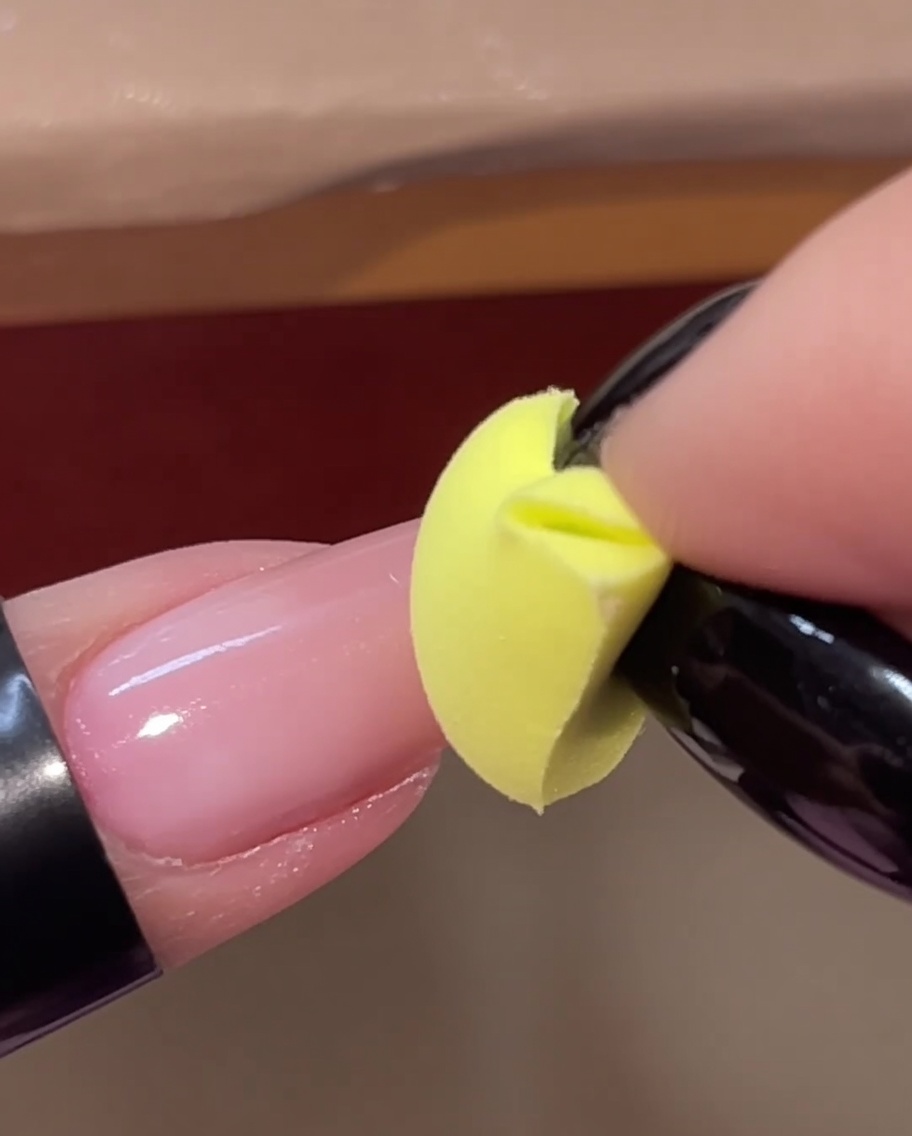 イエローのスポンジで2層目のピンクジェルをネイルの先端に重ねている様子。