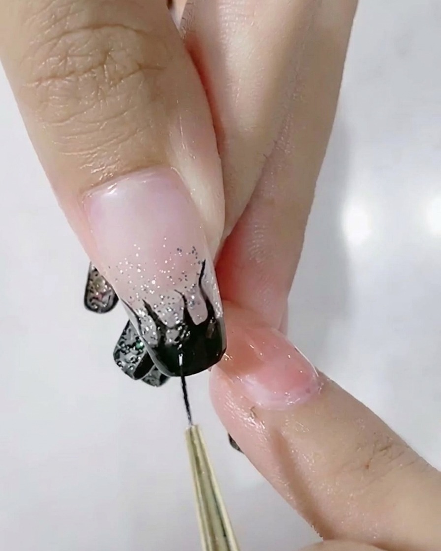 ライナーブラシで黒い炎のアートを塗りつぶしている様子