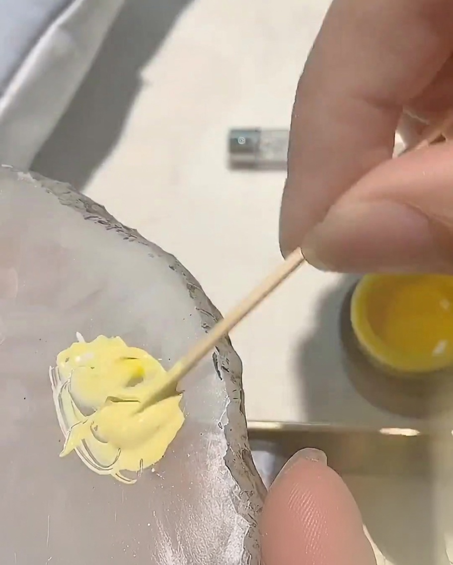 パレット上のイエロージェルに、ごく少量のレッドジェルを足している様子