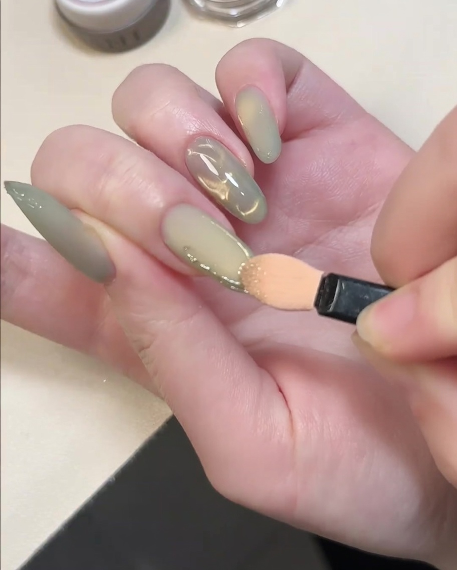 アイシャドウチップを使用して、盛り上がった3Dジェルラインにゴールドクロムパウダーを擦り付けている様子。