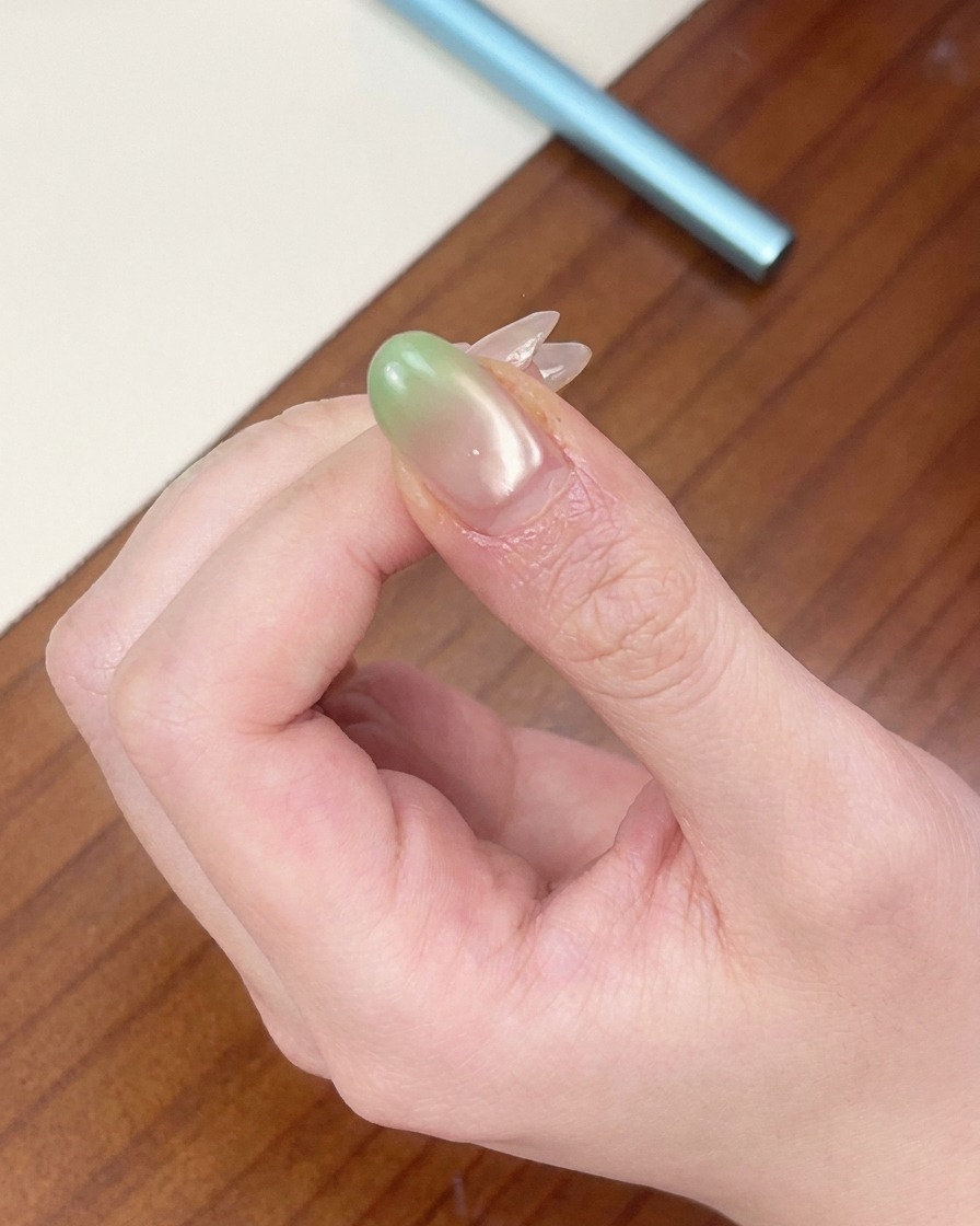 グリーンネイルの先端を、赤いミニUVランプで硬化させている様子。