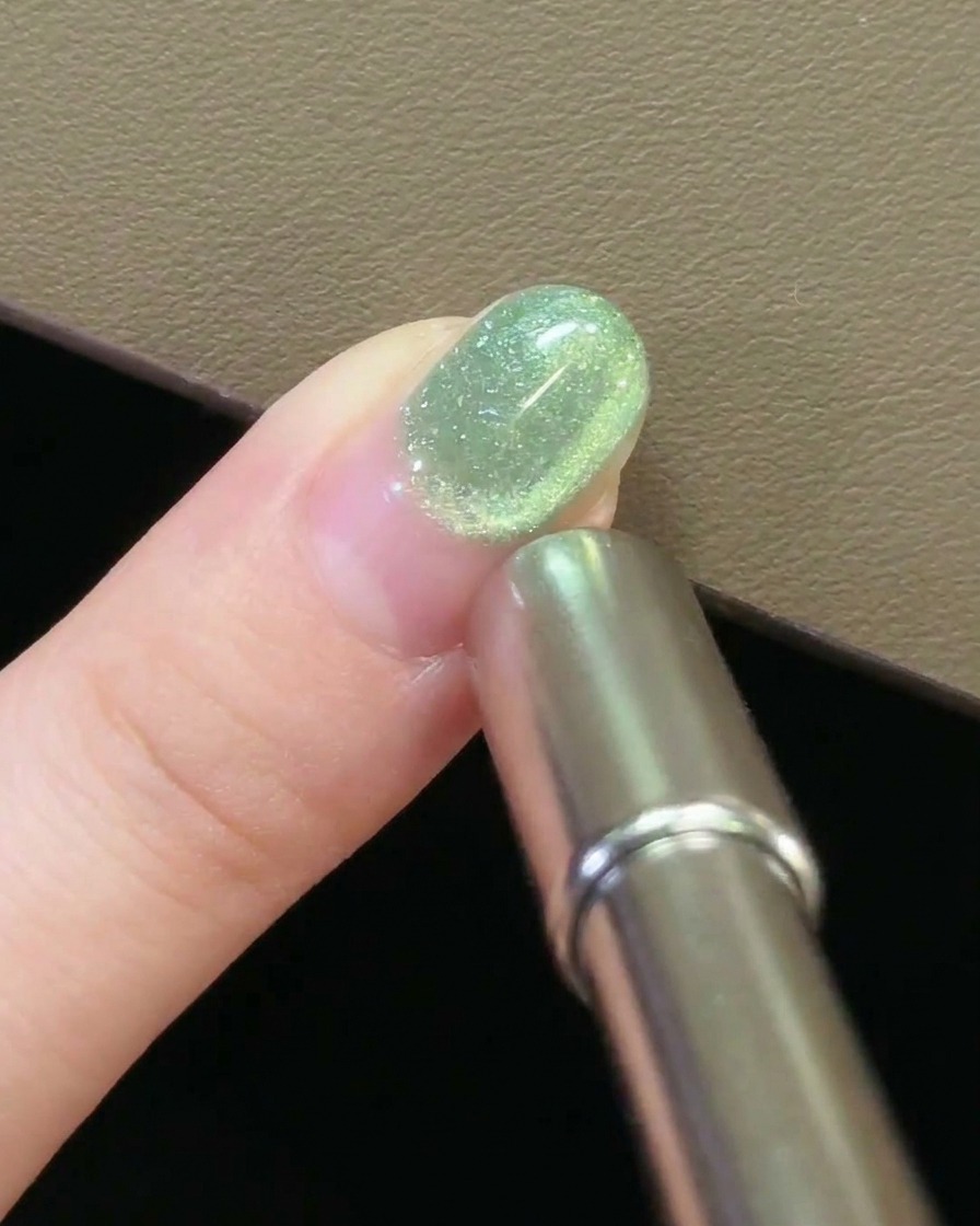 爪の上でマグネットを円を描くように動かし、キャッツアイジェルの模様を作っているアップ画像。